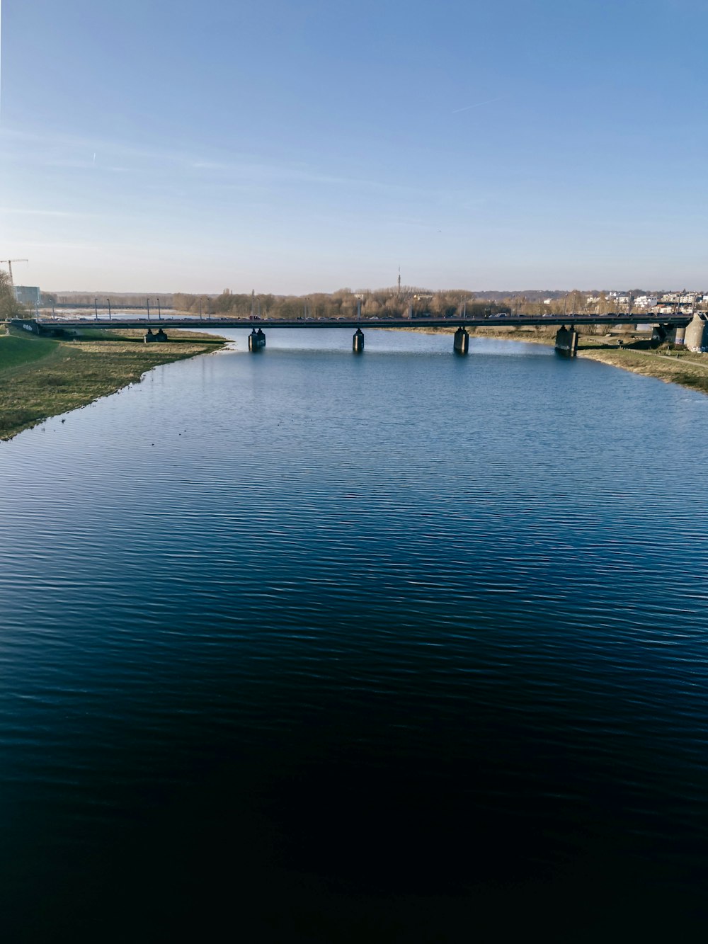 a body of water with a bridge in the background