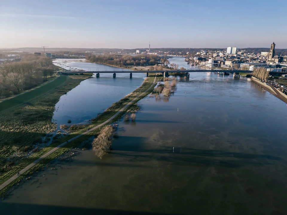 Aerial view of a city with a river flowing through it and surrounding landscape