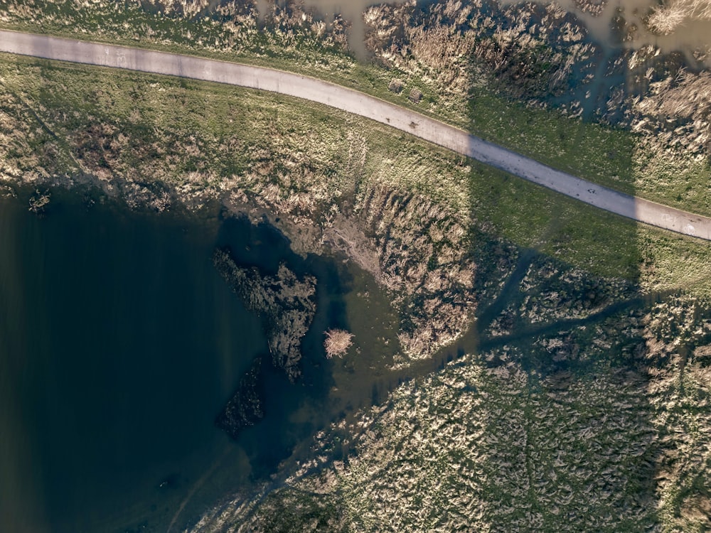 an aerial view of a road and a body of water