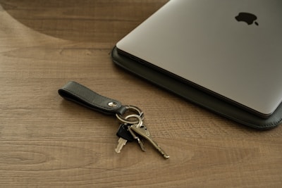 Close-up of the sleek black Bluetooth tracker attached to a set of keys on a modern desk.