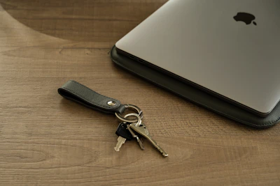 Close-up of the sleek black Bluetooth tracker attached to a set of keys on a modern desk.