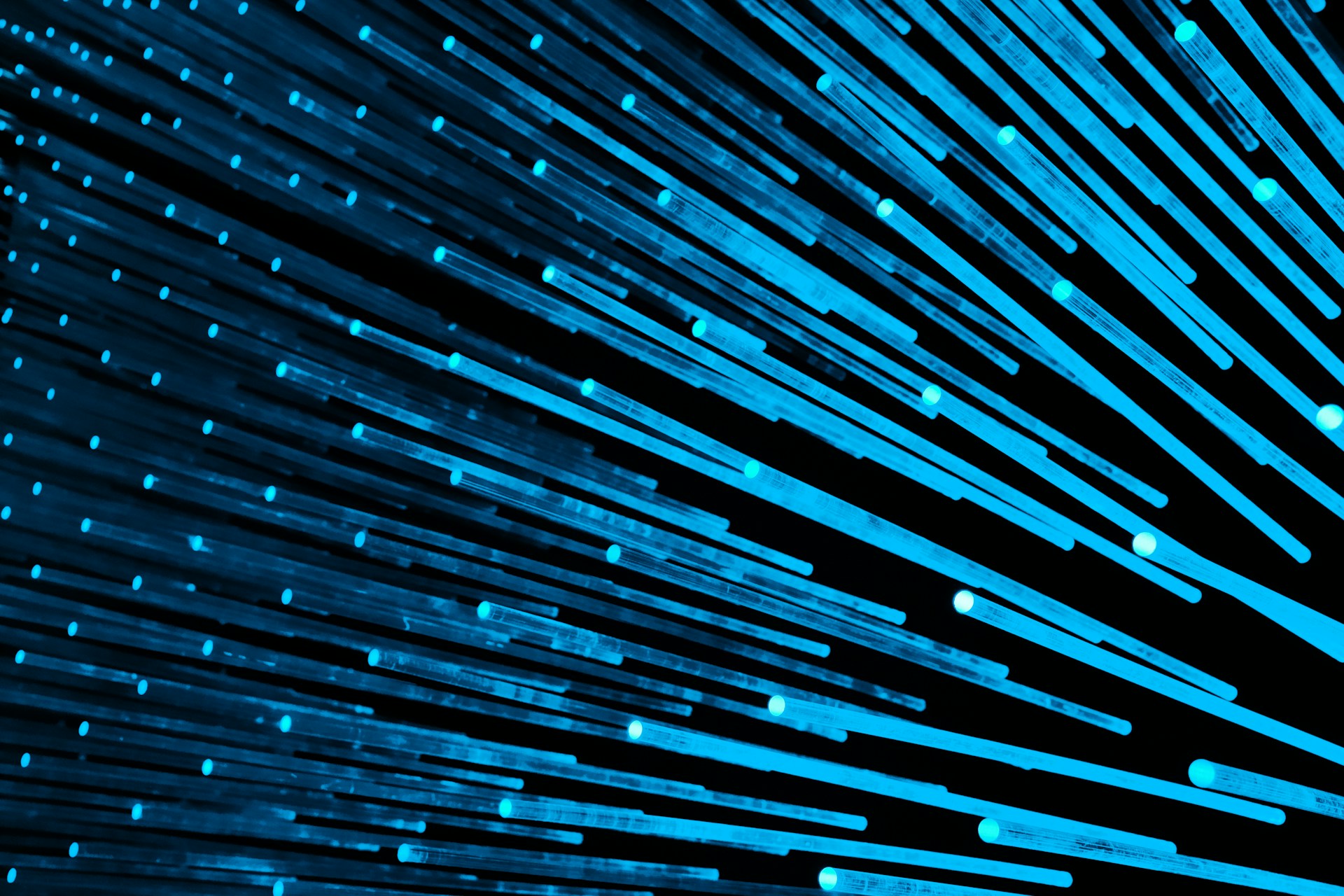 Multiple blue light streaks are extending diagonally across a dark background, creating a sense of motion and energy.