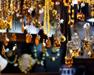 Elegant Telkârî silver jewelry and amber gifts displayed on a traditional fabric.