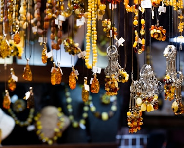 Elegant Telkârî silver jewelry and amber gifts displayed on a traditional fabric.
