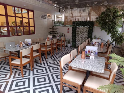 A vibrant Rajwadi Chai outlet with deep red and gold decor, bustling with happy customers.