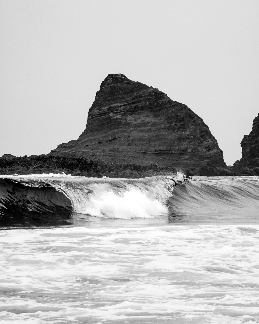 a black and white photo of a wave in the ocean