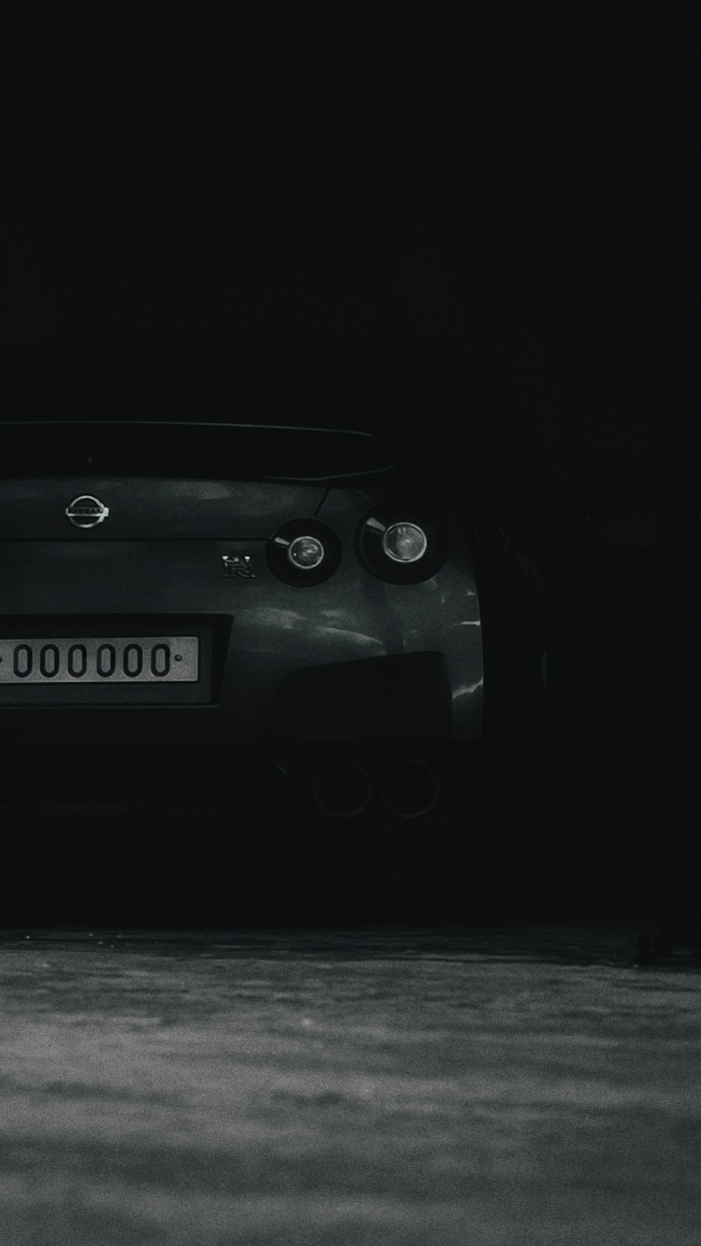 a black and white photo of a car in the dark