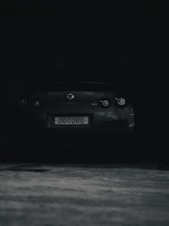 Dark moody image of a license card being held over a car dashboard.