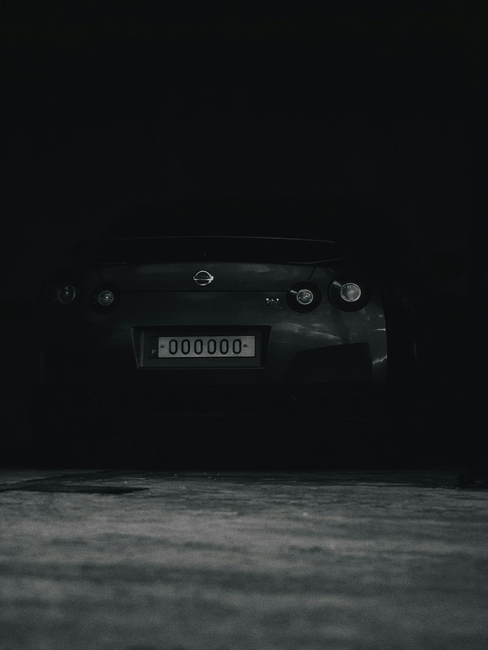 a black and white photo of a car in the dark