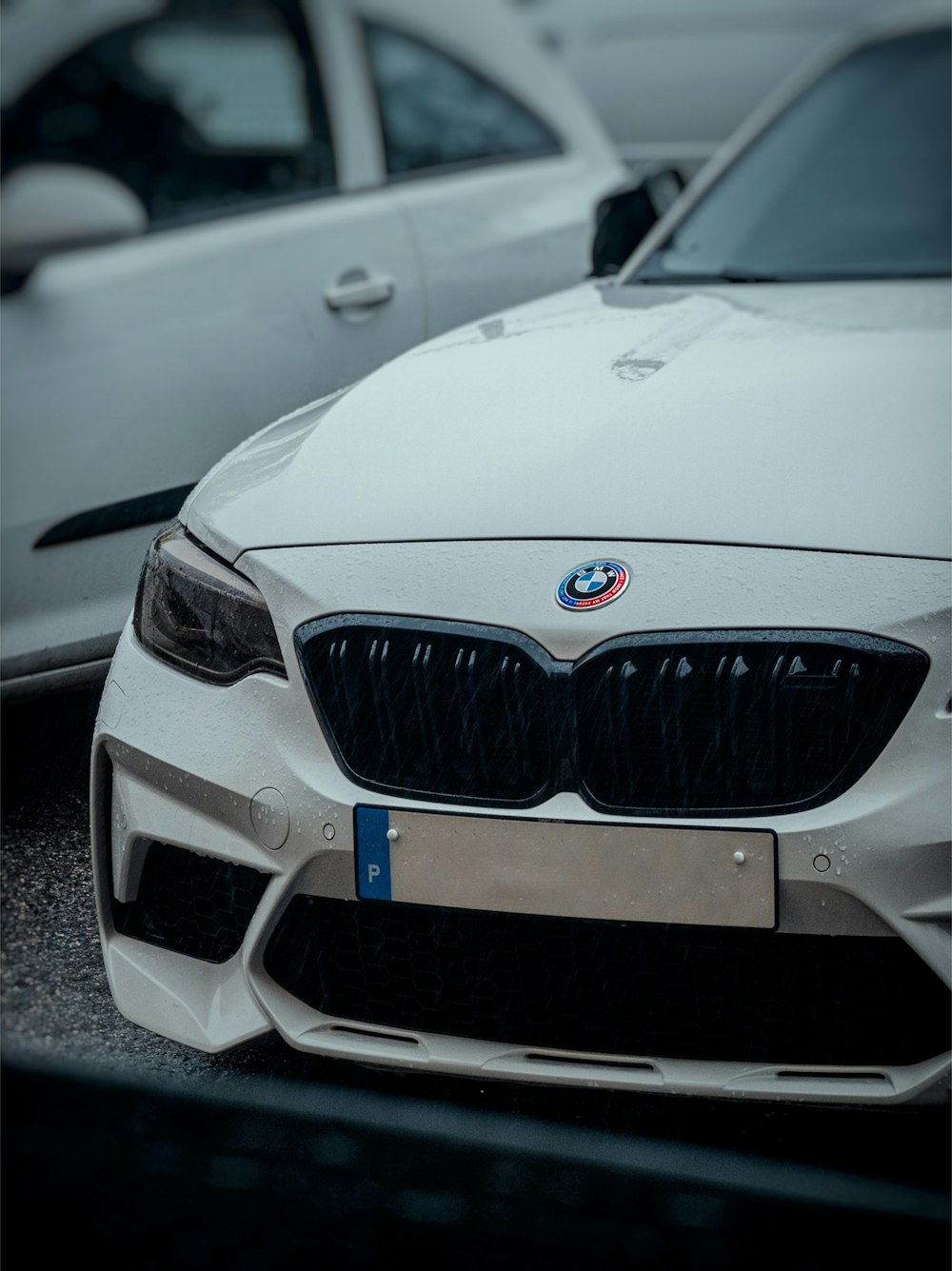 a white car parked in a parking lot next to other cars