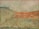 A textured painting with abstract brushstrokes depicting a landscape. Swirls and dabs of green and orange suggest grasslands or fields with rolling hills in the background. A mix of muted earth tones conveys a natural scene.