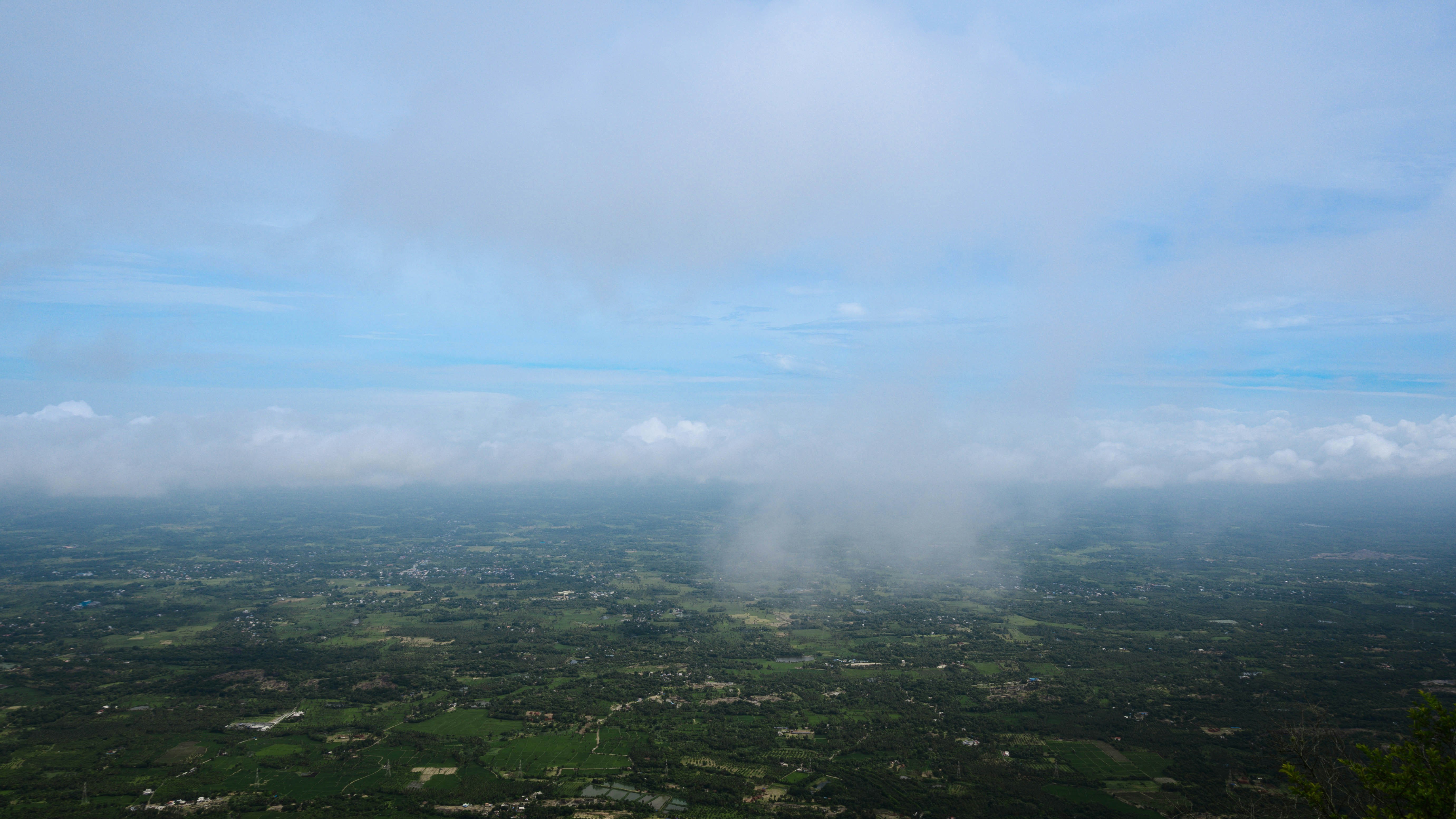 pemandangan udara pedesaan hijau subur di bawah langit biru mendung