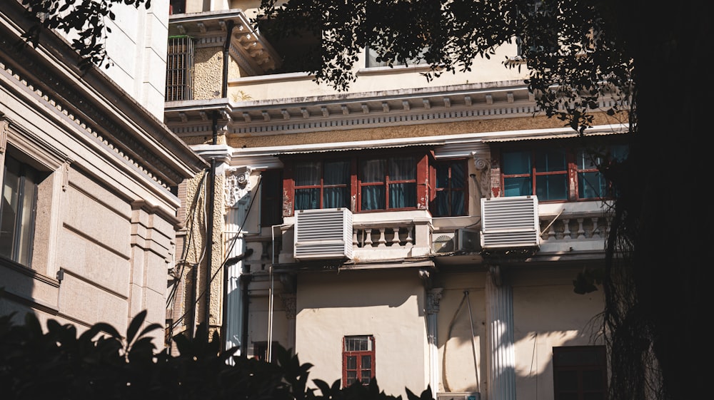 a tall building with red shutters and balconies