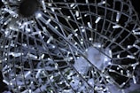 A close-up view of a spherical wire structure adorned with numerous small, white LED lights. The sphere appears to be part of a decorative outdoor installation, glowing brightly against a dark background. Snow is visible on some of the structure, enhancing the wintry atmosphere.