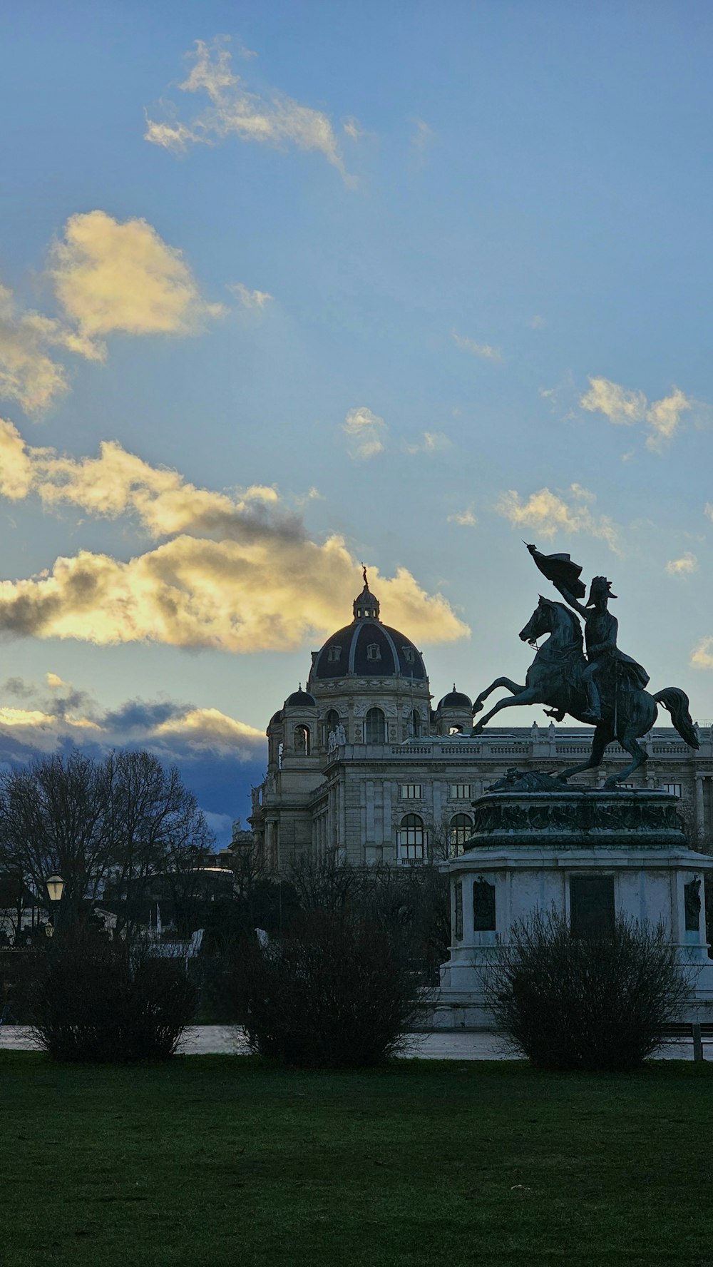 a statue of a man riding a horse in front of a building