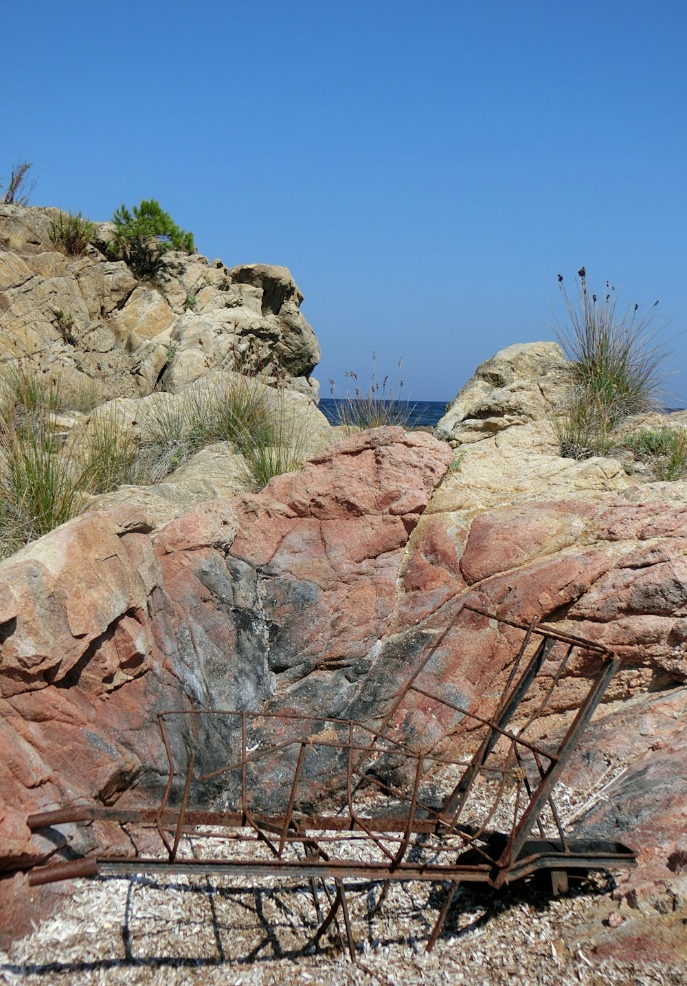 a rusted metal structure sitting on top of a rocky hillside