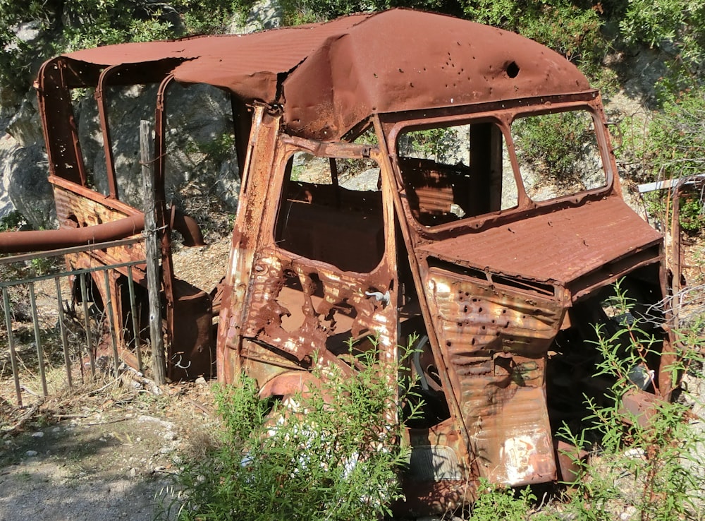 an old rusted out truck sitting in a field