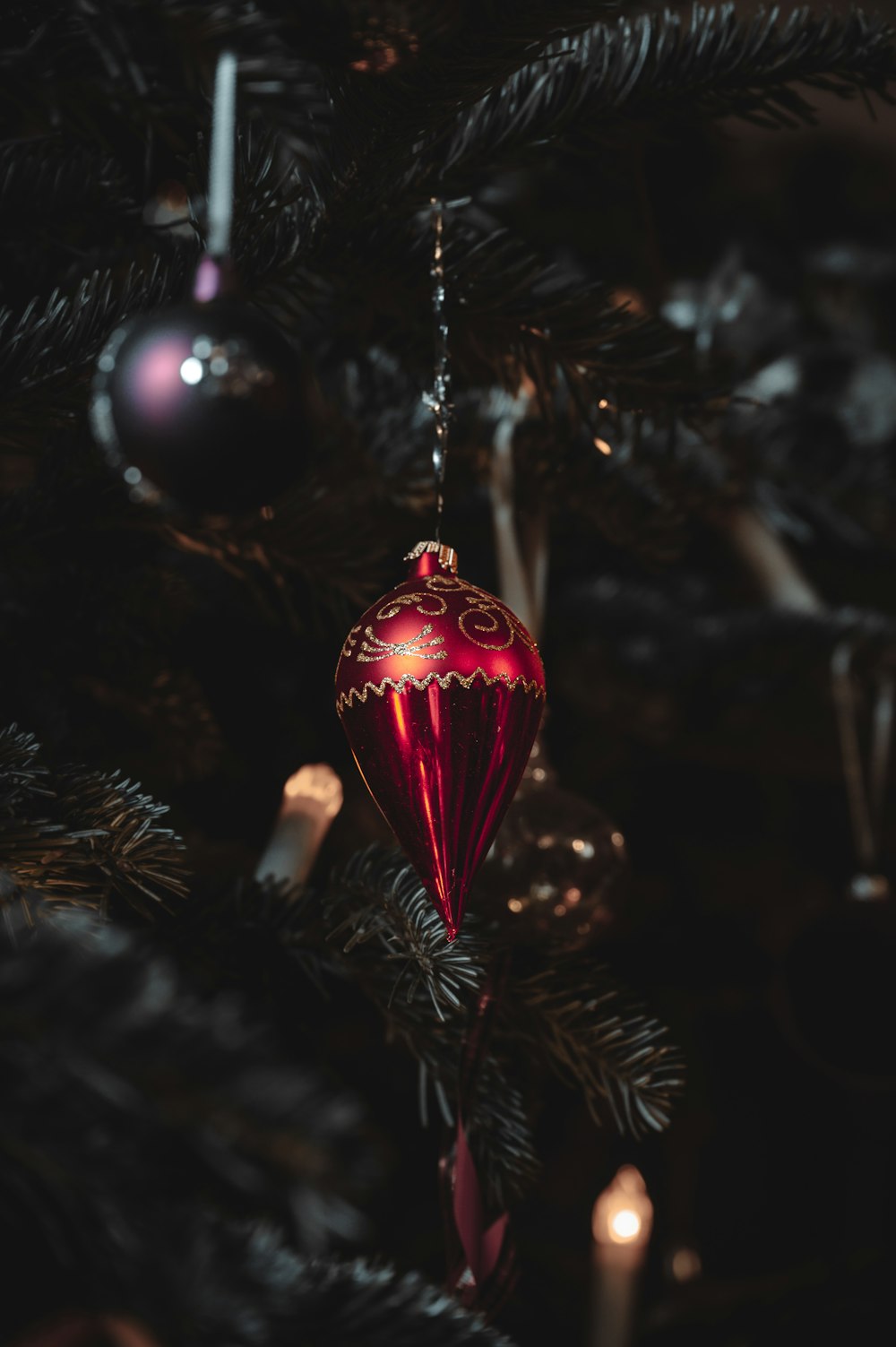 a red ornament hanging from a christmas tree