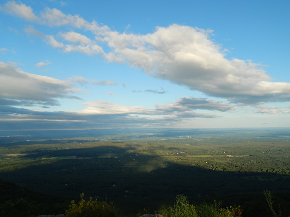 a view of a green valley and a blue sky