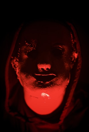 Concept art showing a mysterious character in a shadowy environment with white and red highlights.