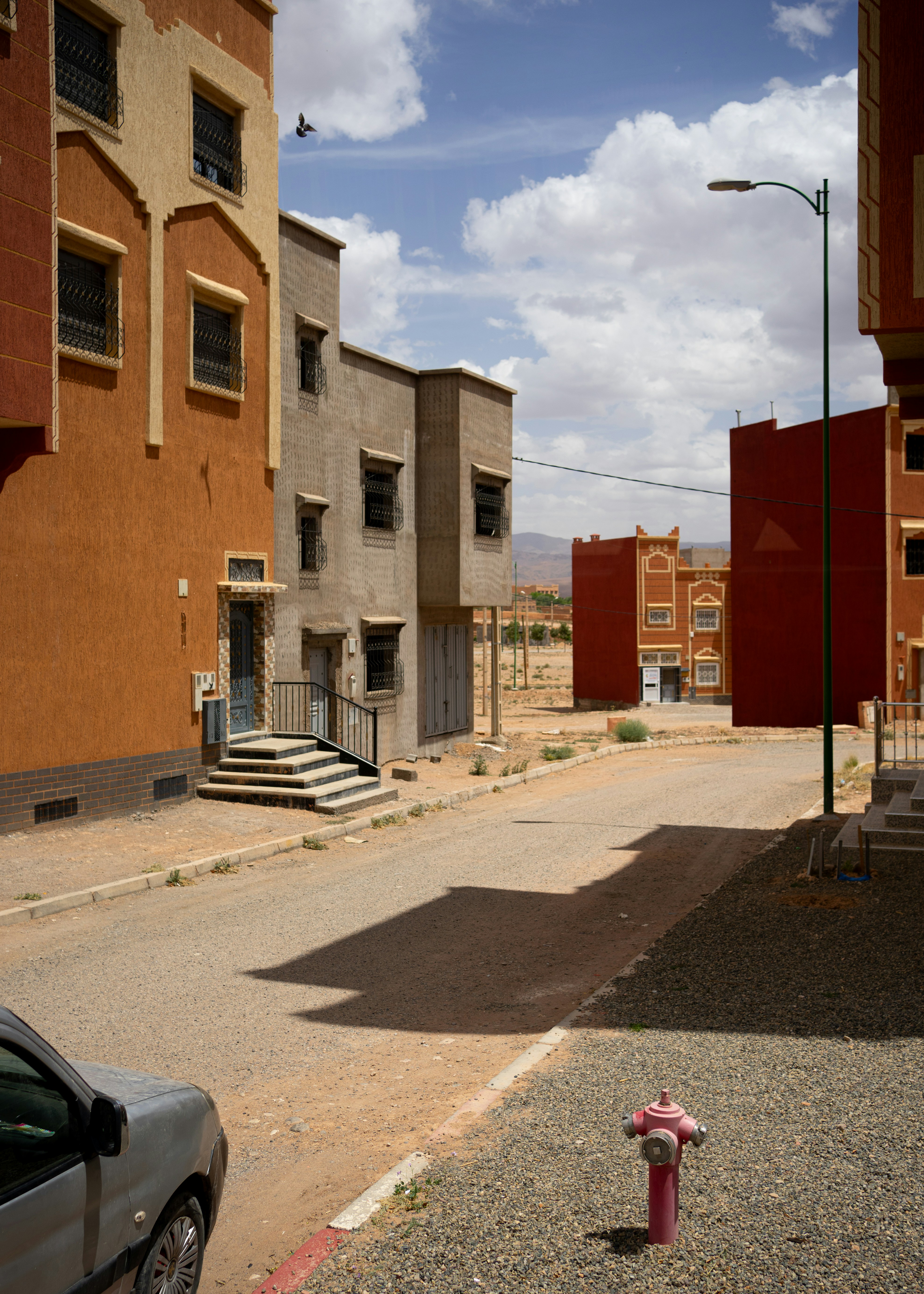 un idrante rosso seduto sul ciglio di una strada