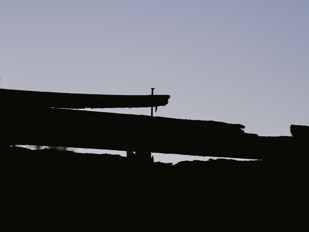 a bird standing on top of a wooden structure