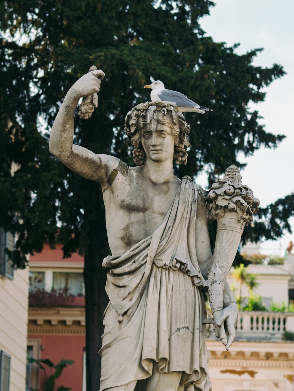 a statue of a man with a bird on his head
