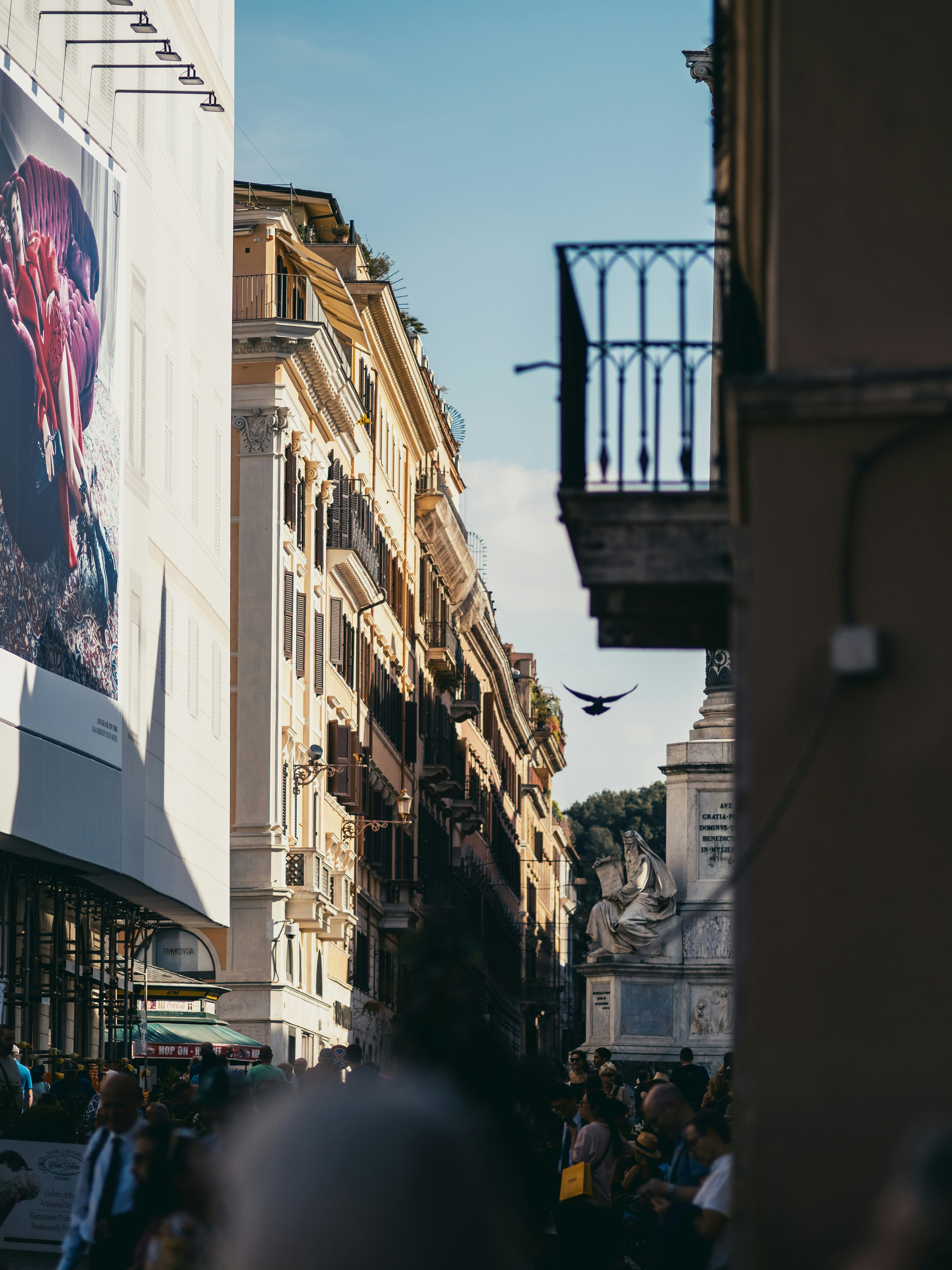 高層ビルの横の通りを歩く人々の群れ