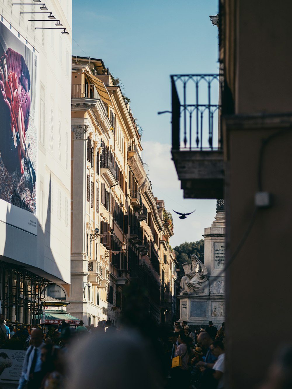 a crowd of people walking down a street next to tall buildings