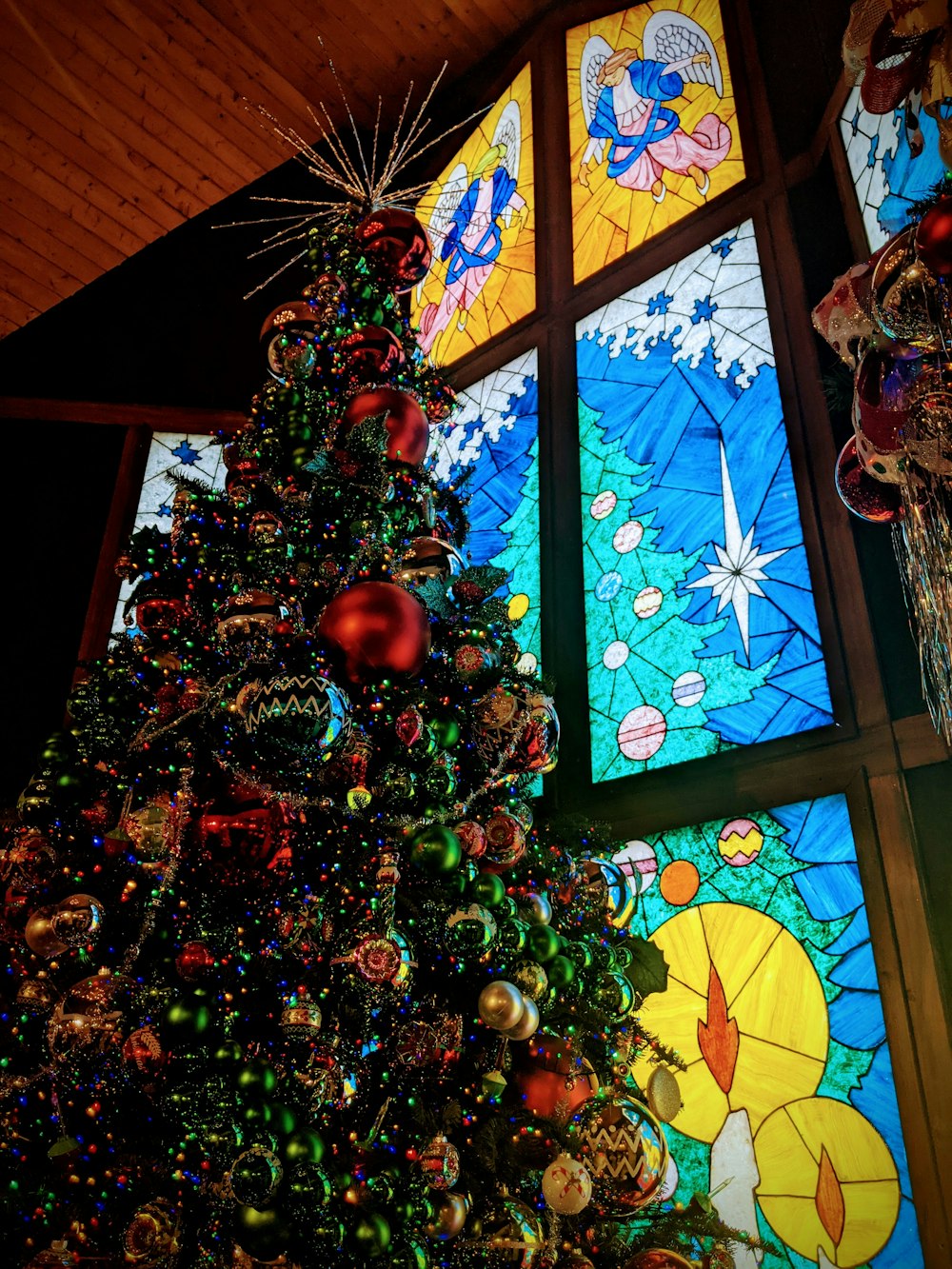 a christmas tree in front of a stained glass window
