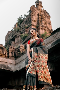 Elegant women's sari draped with traditional temple architecture behind.