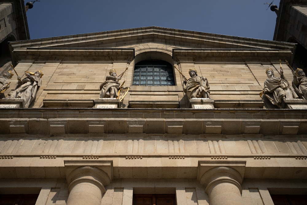 a tall building with statues on the side of it