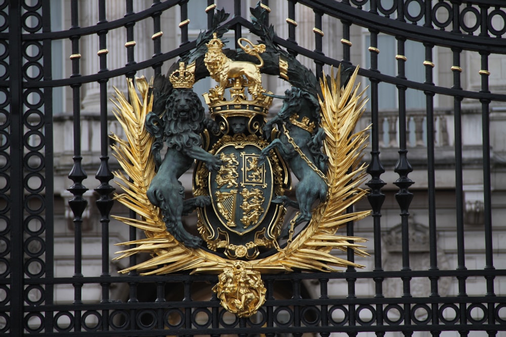 a gold and black coat of arms on a gate