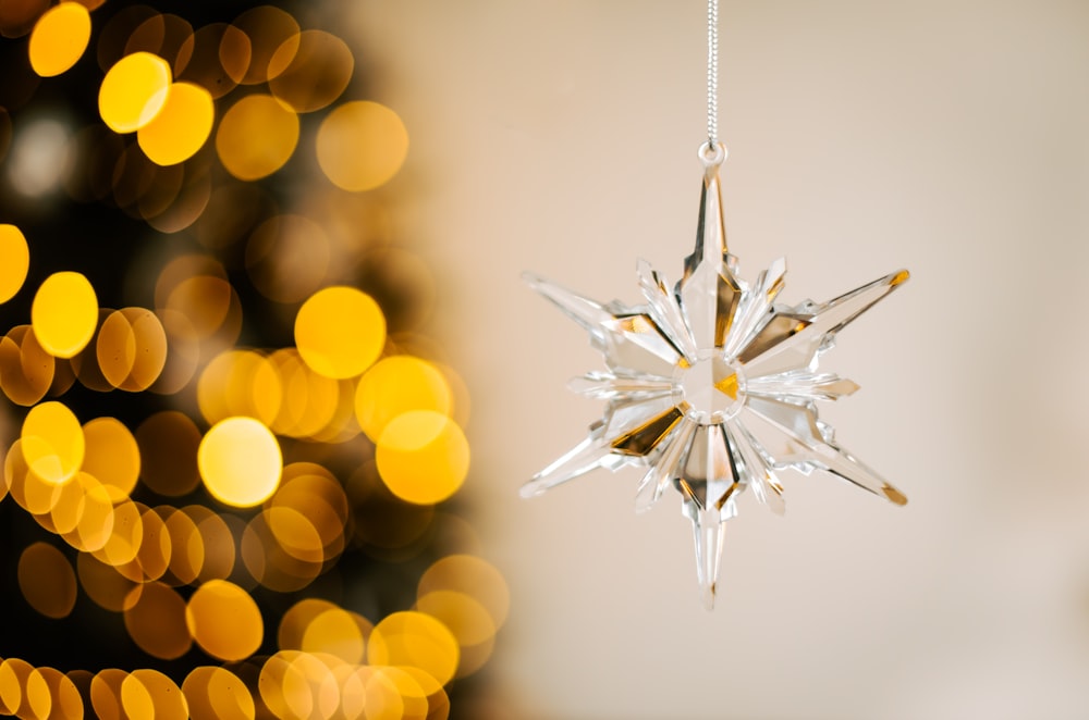 a snowflake ornament hanging from a christmas tree