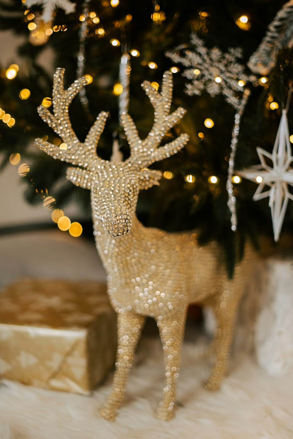 a gold deer figurine next to a christmas tree