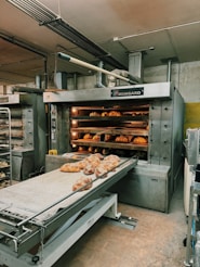 a bakery with a conveyor belt filled with doughnuts
