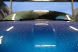 A close-up of water droplets glistening on a car's surface.