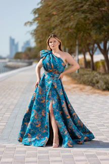 A vibrant plus-size woman confidently wearing a colorful summer dress in a sunny urban setting.
