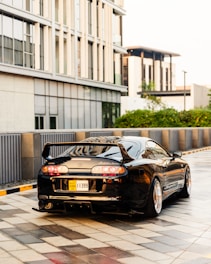 A sleek car being detailed at a driveway.