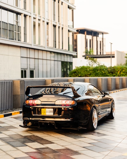 A sleek, shiny car parked in a modern urban driveway, showcasing its immaculate detailing.