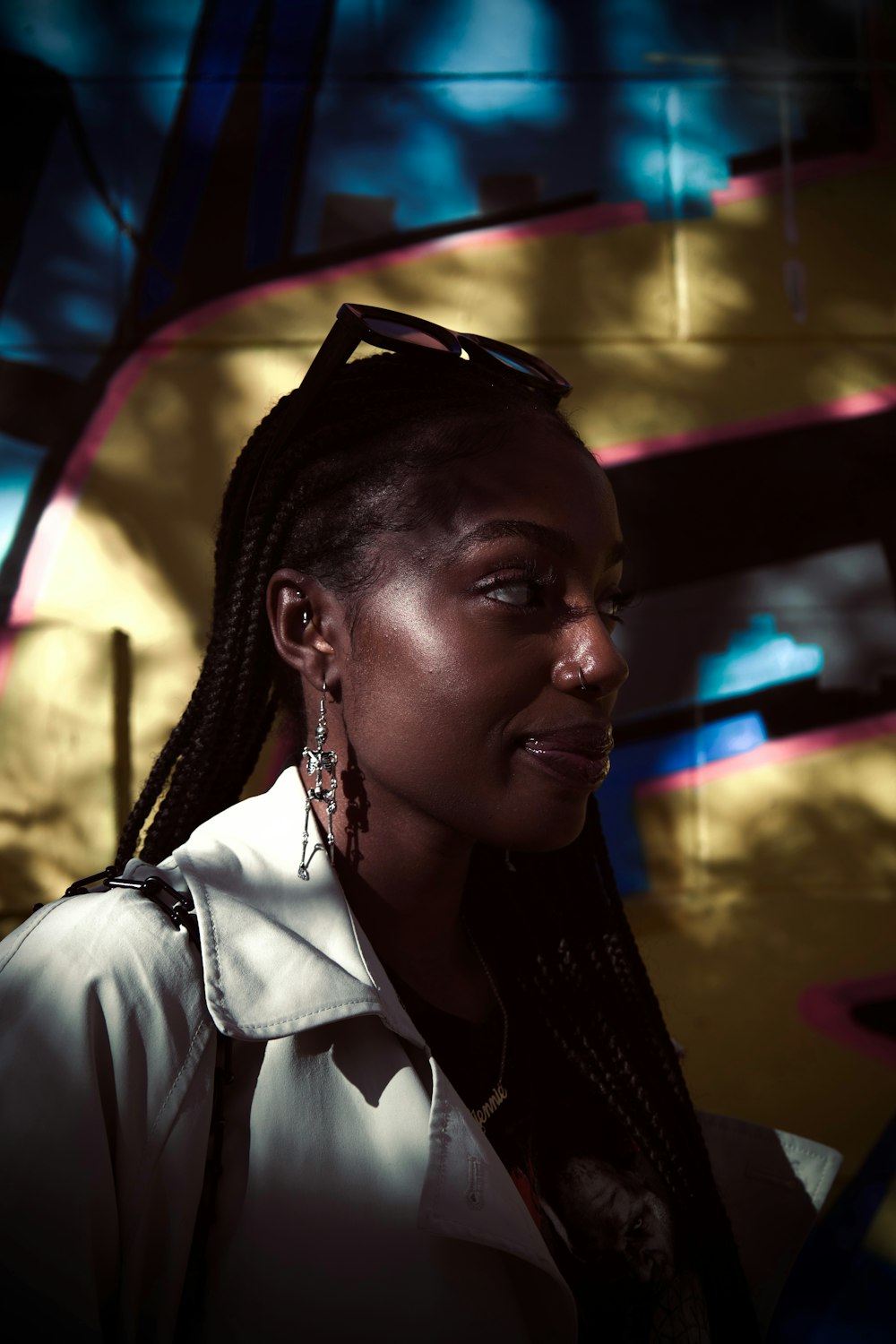 a woman with braids standing in front of a wall