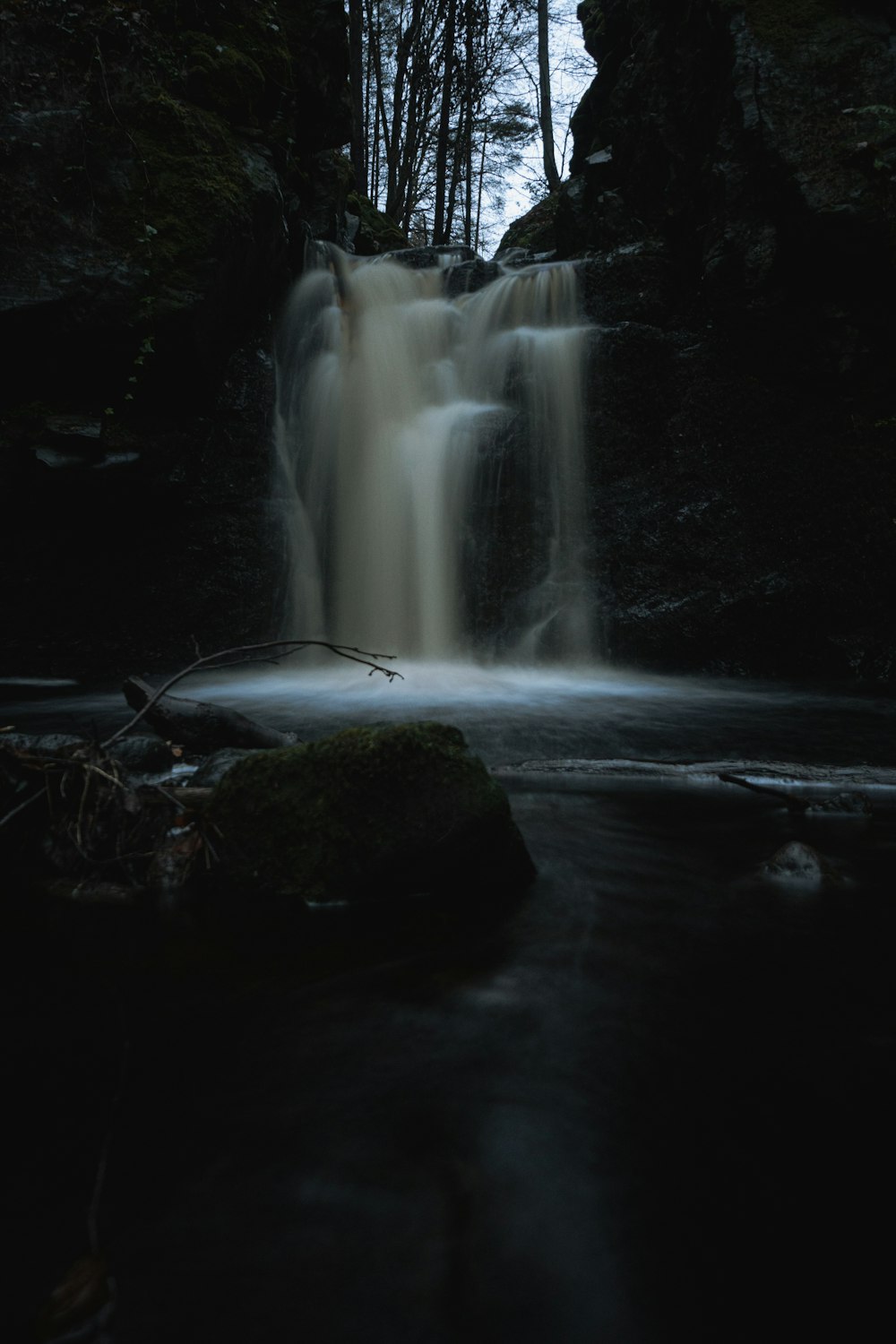 a small waterfall in the middle of a forest