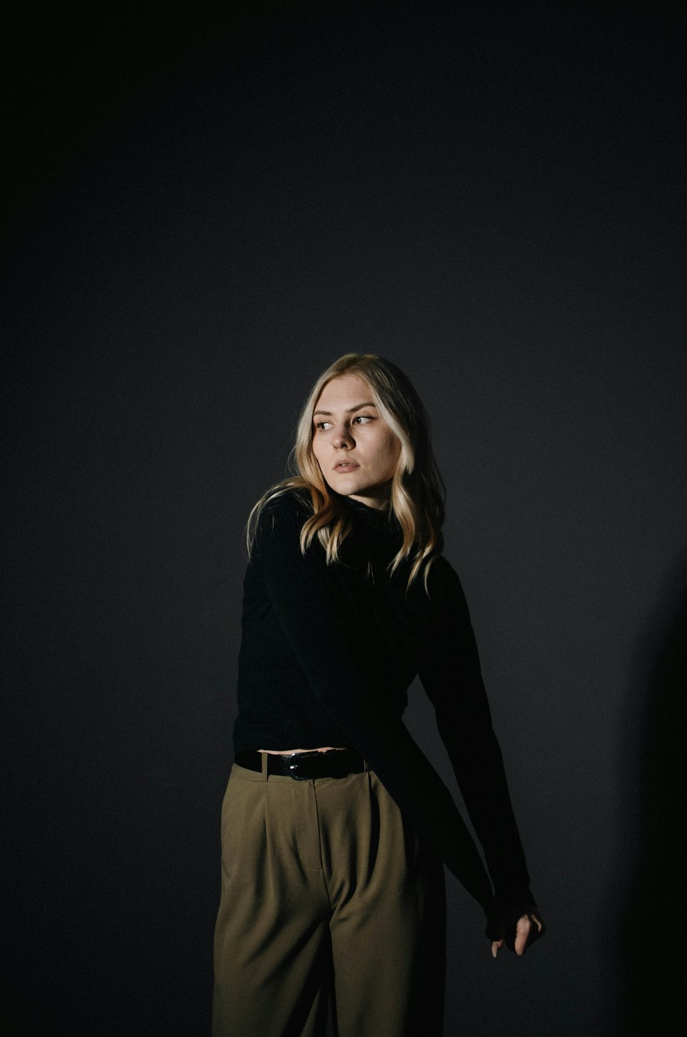 a woman standing in front of a black background