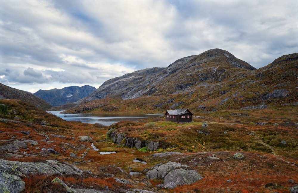 a small house in the middle of a mountain range