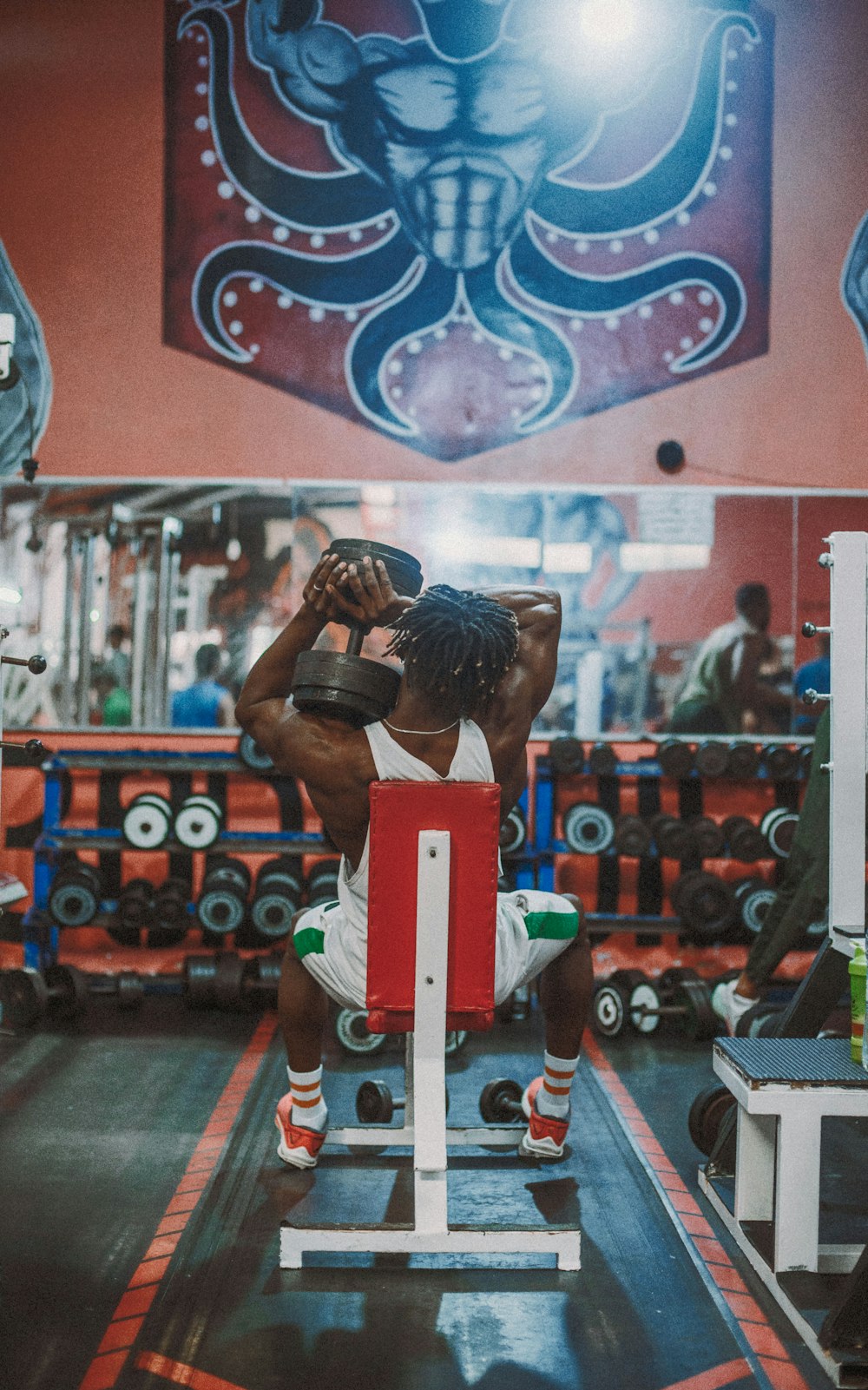 a man squatting on a bench in a gym