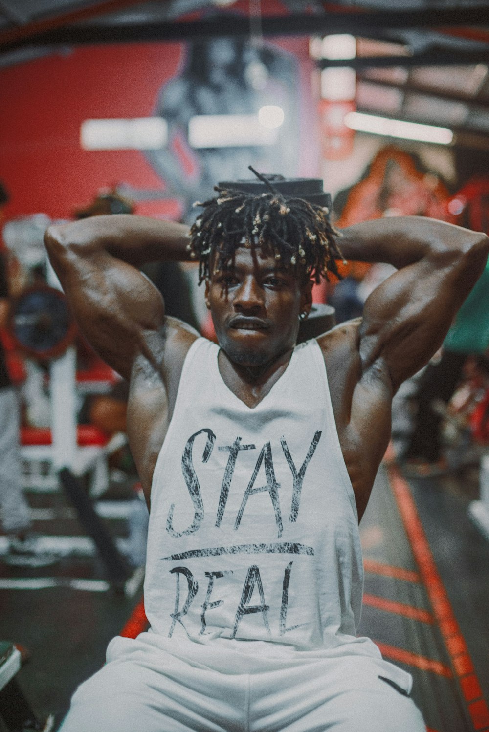 a man with dreadlocks sitting in a gym