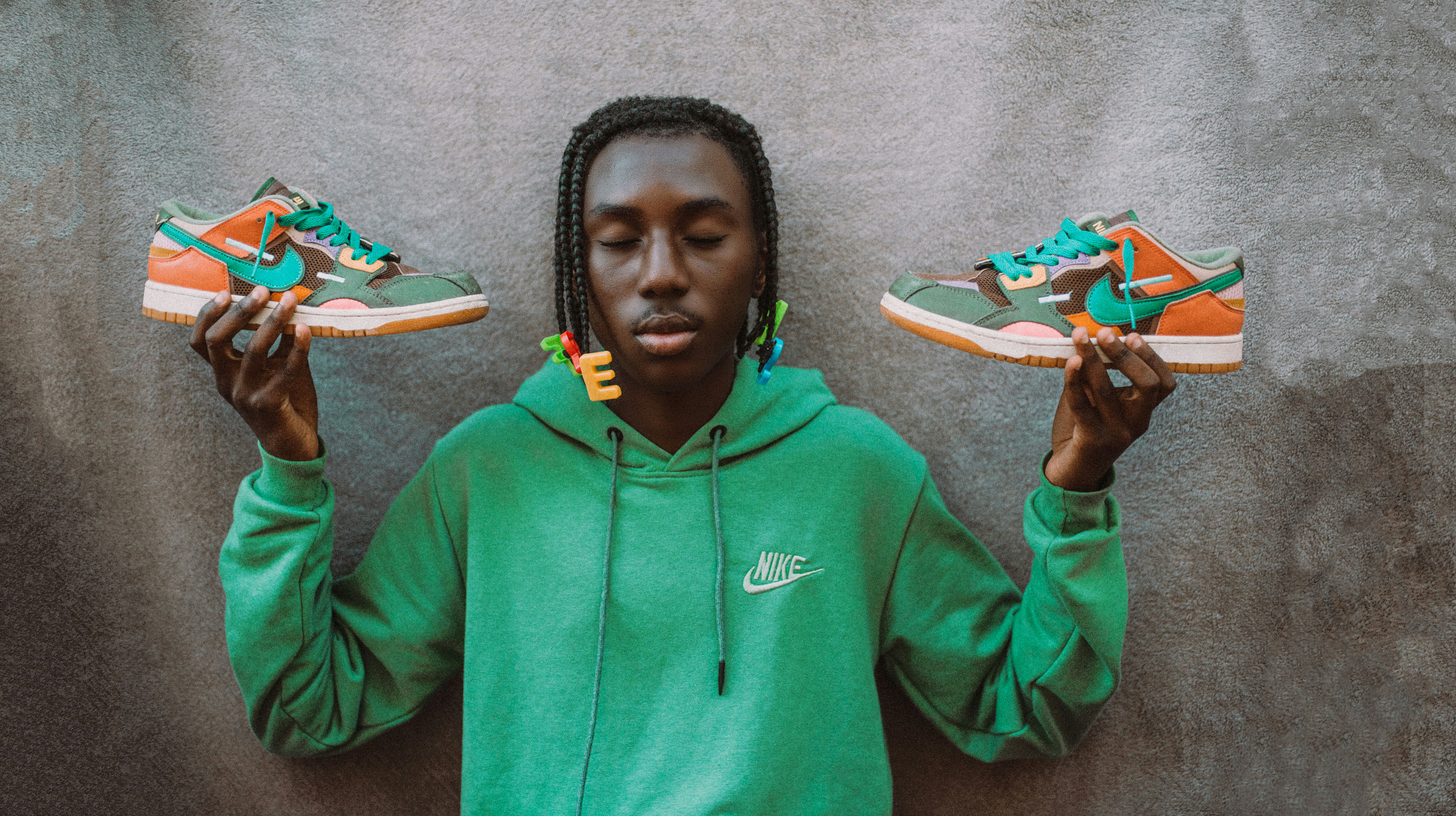 a person holding up two pairs of shoes