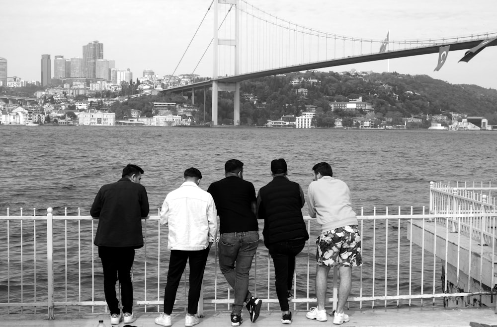 a group of people standing next to each other near a body of water