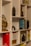 A neatly arranged bookshelf featuring a variety of books, some of which are titled 'Good to Great' and 'The 7 Habits of Highly Effective People'. A decorative metal sculpture resembling a tree with round, golden leaves sits prominently on the shelf, along with marble-patterned vases. Small potted plants add a touch of greenery, while a bicycle-themed book provides a whimsical touch.