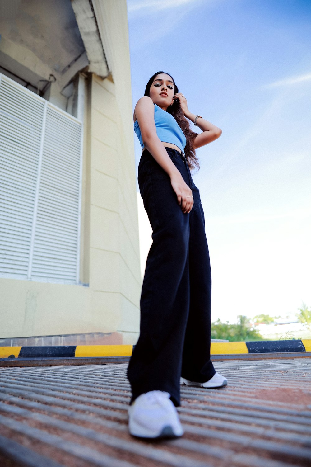 a woman standing on a sidewalk with her hands on her hips